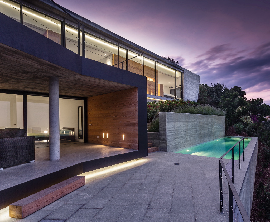 glass house with a swimming pool in the evening on the costa brava
